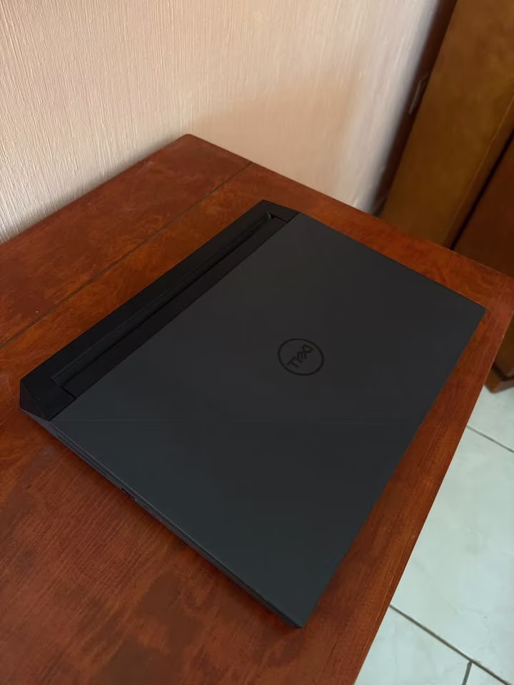 Dell G15-5530 gaming laptop rear lid close-up featuring the matte black finish, centered Dell logo, and distinctive angular lid design