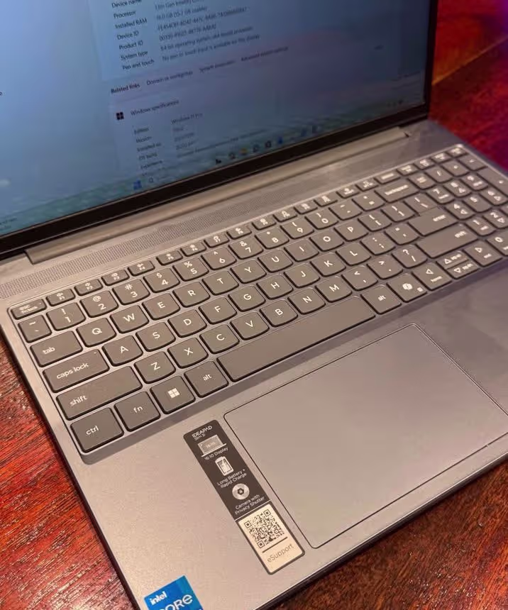Close-up of Lenovo IdeaPad Slim 3 laptop with Intel Core i7 processor, featuring a full-size backlit keyboard with numeric keypad and a large precision trackpad, showcasing the sleek gray finish and ergonomic key layout.