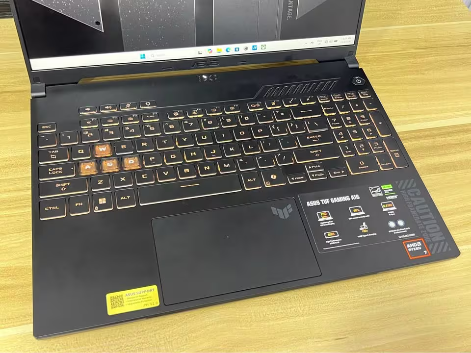 ASUS TUF A16 Ryzen 7 gaming laptop showing the backlit keyboard, numeric keypad, and large touchpad in close view