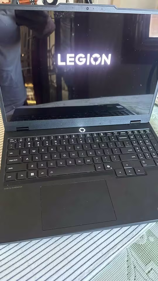Lenovo Legion 5 laptop close-up showing the Legion boot logo, full-size keyboard, and touchpad