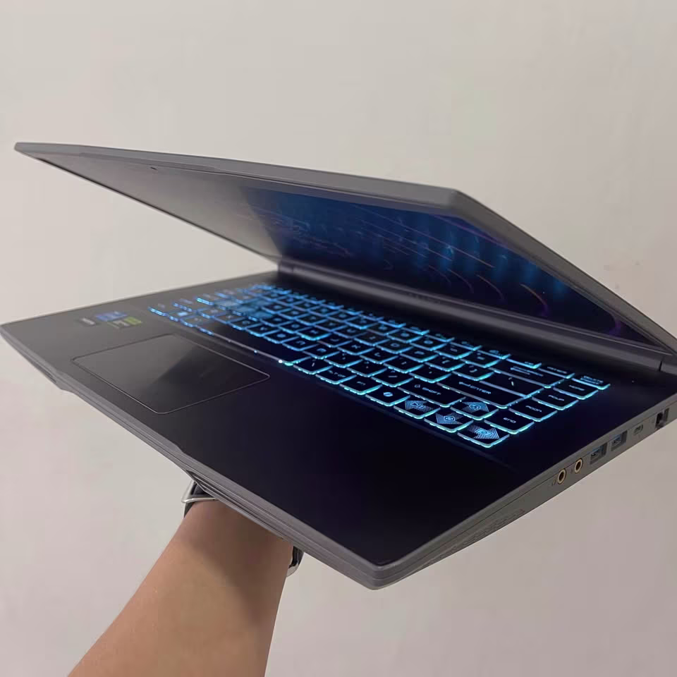 MSI Thin 15 gaming laptop with Core i5 processor and RTX 3050 graphics, shown in a hand-held build quality test highlighting its slim 2.2 kg design.